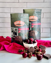 Load image into Gallery viewer, Chocolate Cherry Crunch, Nana Joe&#39;s granola packages with cherries and BTR Nation chocolate hearts on a pink cloth
