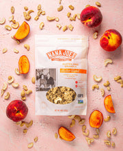 Load image into Gallery viewer, Nana Joes Granola Organic Cluster Peach and Cashew Butter blend on a pink background with peaches and cashews
