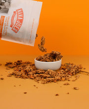 Load image into Gallery viewer, Nana Joes Granola Organic Cluster Peach and Cashew Butter blend pouring into white bowl on orange background
