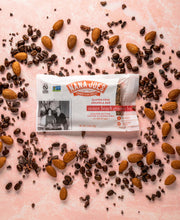 Load image into Gallery viewer, Ocean Beach Granola Bar by Nana Joes Granola on a pink background with almonds and coffee beans
