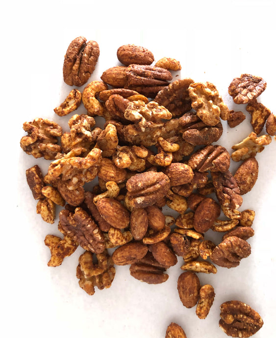 A pile of Orange Spiced Mixed Nuts by Nana Joes Granola on a white table