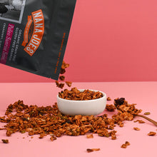 Load image into Gallery viewer, Nana Joes Granola bag spilling into a white bowl on a pink background.
