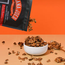 Load image into Gallery viewer, Nana Joes Granola bag spilling into a white bowl on an orange background.

