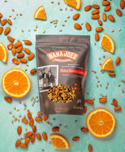 Load image into Gallery viewer, Nana Joes Granola Paleo Sunrise Orange blend with oranges and almonds on a light blue background
