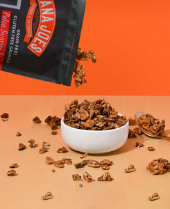 Nana Joes Granola Paleo Sunrise Orange granola pours into a white bowl on an orange background