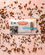 Load image into Gallery viewer, Swell Grain Free Bar by Nana Joes Granola, pink background with coconut and coca nibs sprinkled about
