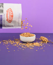 Load image into Gallery viewer, Nana Joes Granola Organic Savory Muesli Blend pouring into white bowl on purple background
