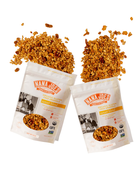 Two open bags of Nana Joes Granola with scattered granola on a white background