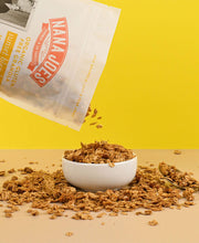 Load image into Gallery viewer, Nana Joes Granola being poured from a bag into a bowl on a yellow background
