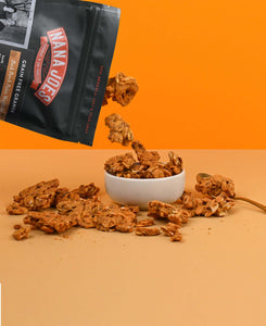 Nana Joes Granola bag spilling into a white bowl on an orange background.